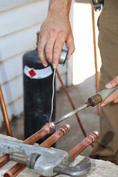 Soldering copper pipe during a plumbing repair in Merced, CA