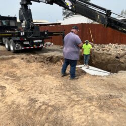 Crane installing septic tank